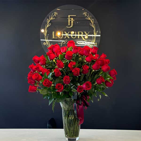 An impressive arrangement in a vase with 100 natural roses and greenery (ruscus), ideal for extraordinary moments.