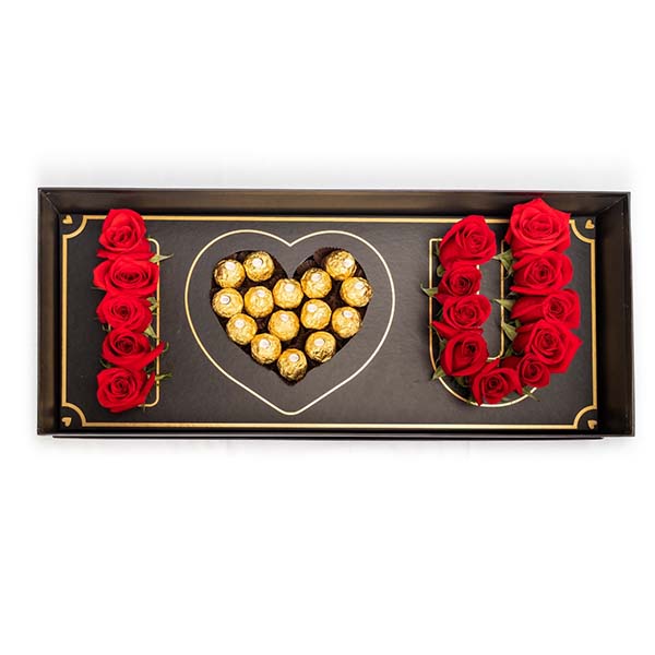 Arrangement of 15 to 20 fresh roses with approximately 15 Ferrero Rocher chocolates, in a sophisticated i love you box. Open in white background.